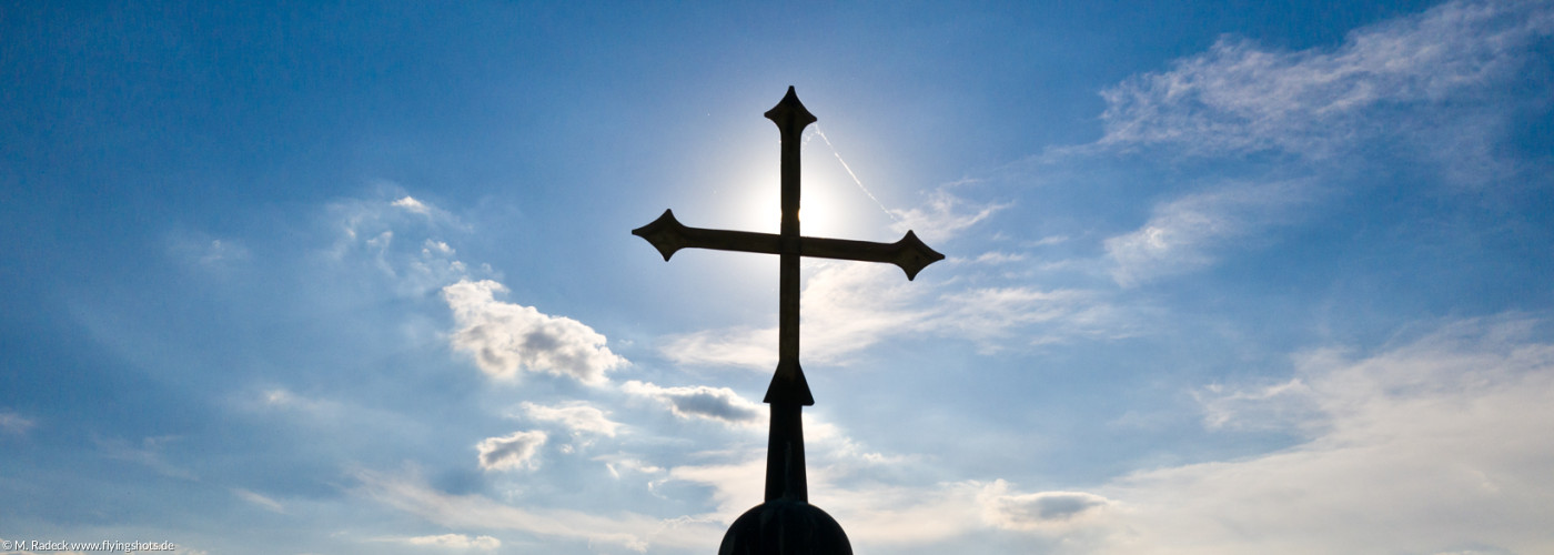 Turmkreuz vor der Sonne